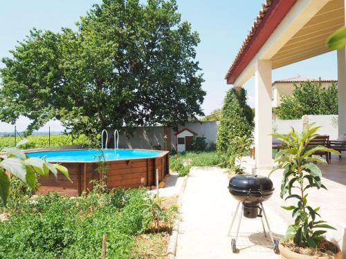 un bain à remous dans un jardin avec barbecue dans l'établissement Holiday Home near Pont du Gard & Vineyards, à Domazan