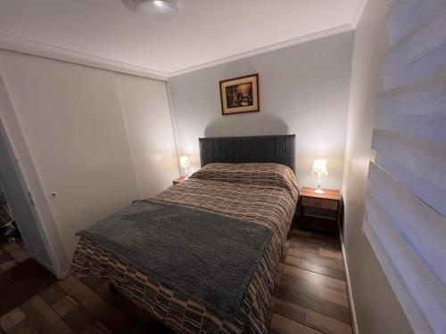 1 dormitorio pequeño con 1 cama y 2 lámparas en CÓMODO Y RENOVADO DEPARTAMENTO CON VISTA AL MAR en Arica