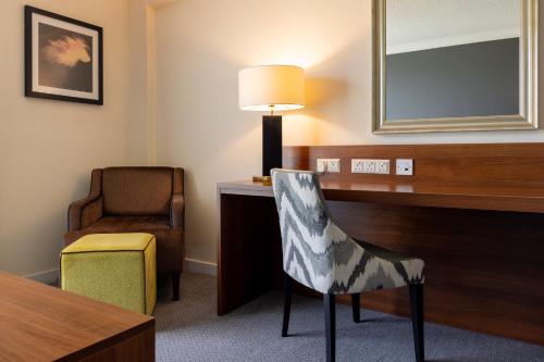 a room with a chair and a desk and a lamp at Holiday Inn Newcastle Gosforth Park by IHG in Newcastle upon Tyne