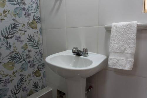a white bathroom with a sink and a shower curtain at Green House in Lima