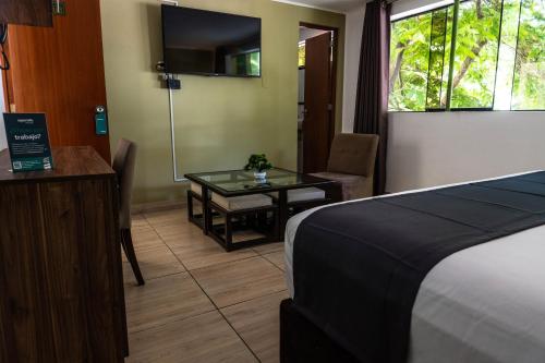um quarto de hotel com uma cama e uma mesa de vidro em Green House em Lima