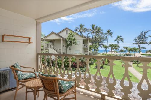 a balcony with chairs and a view of the ocean at Aston Islander On The Beach in Kapaa