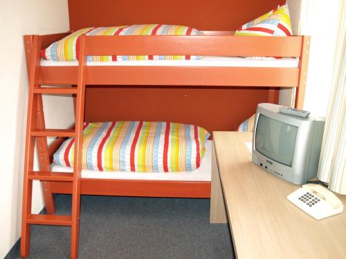 a bunk bed with a computer and a desk with a computer monitor at Gasthof zur Sonne in Jettingen-Scheppach