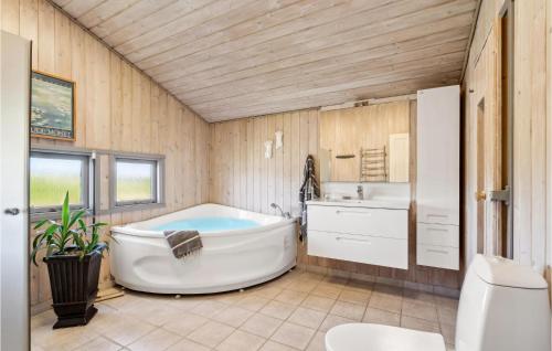 BjerregårdにあるBeautiful Home In Hvide Sande With Wifiのバスルーム(バスタブ、シンク付)