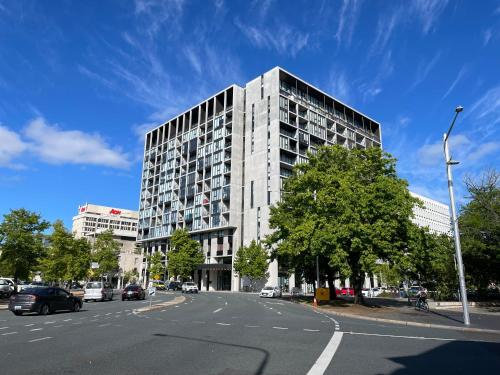 un edificio alto en una calle de la ciudad con una carretera en Lovely CBD two bedroom apartment free parking en Canberra