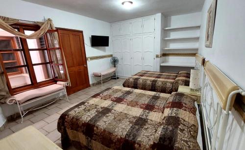 a hotel room with two beds and a tv at Hotel Morada de los Angeles in Calera Víctor Rosales
