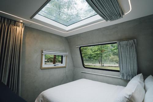 a bedroom with a bed and a skylight at 天ㄟ露營車 in Dongshan