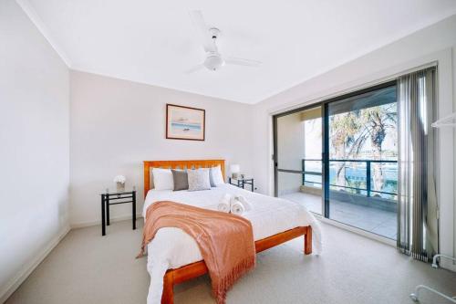 a bedroom with a bed and a large window at Waterfront Townhouse - One in Port Lincoln