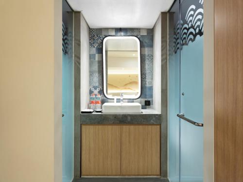 a bathroom with a sink and a mirror at Hotel Santika PasirKaliki in Bandung