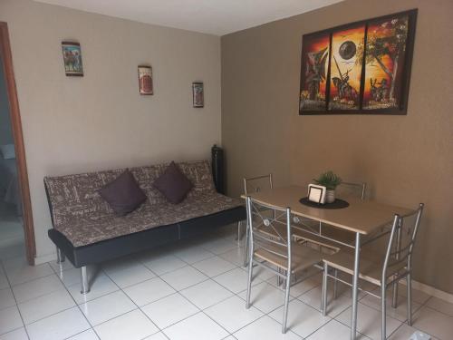 a living room with a couch and a table at Agradable y cómodo departamento a 5 minutos del aeropuerto in Mexico City