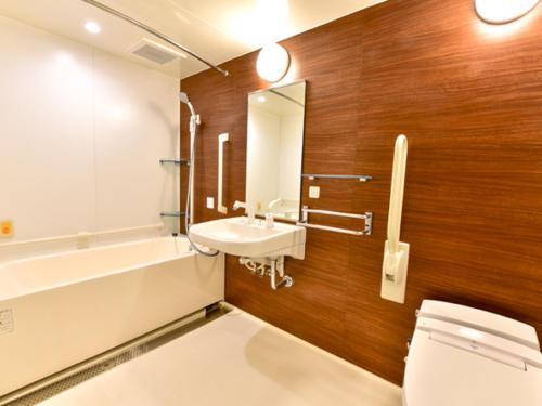 a bathroom with a toilet and a sink and a tub at HOTEL LiVEMAX Fukuoka Tenjin West in Fukuoka