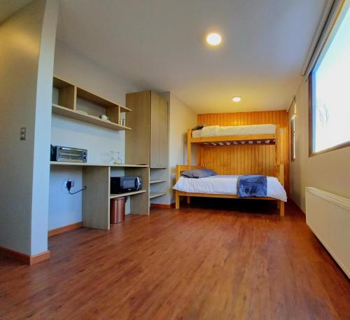 - une chambre avec un lit et du parquet dans l'établissement Refugio Kondortal, à Farellones