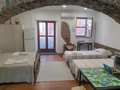 a room with three beds and a room with a tv at Sicily House Soprano in Santo Stefano di Briga