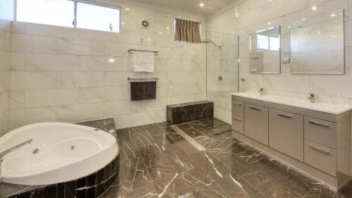 a white bathroom with a sink and a mirror at Silver Haven Motor Inn in Broken Hill