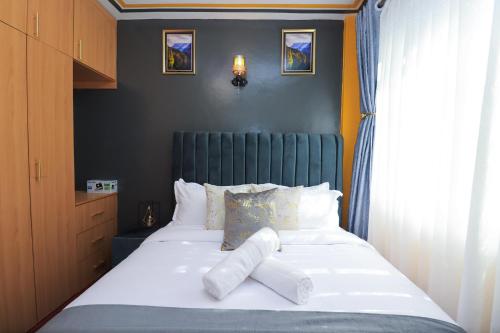 KiambuにあるJoy fully furnished & serviced apartmentsのベッドルーム1室(ベッド1台、タオル2枚付)