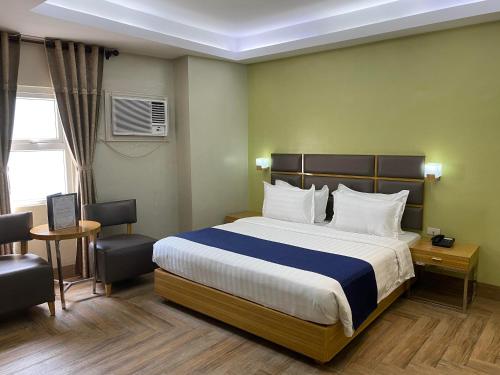 um quarto de hotel com uma cama grande e uma secretária em Sun Star Grand Hotel em Manila