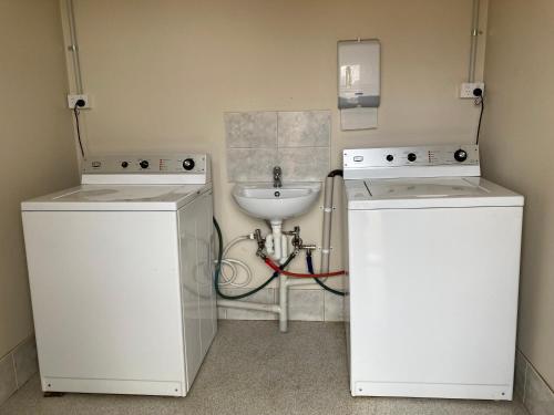 a bathroom with two machines and a sink at Inspirations Mullewa in Mullewa