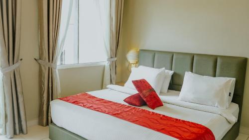 a bedroom with a bed with red pillows and a window at Destini Akef Villa in Pantai Cenang