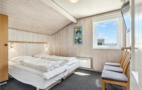 a bedroom with two beds and a window at Nice Home In Hvide Sande With 4 Bedrooms, Sauna And Wifi in Bjerregård