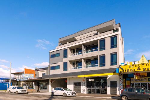 a white building with cars parked in front of it at Punthill Essendon North in Melbourne