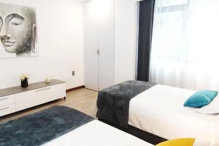 a bedroom with two beds and a picture of a woman at Rivera MaiaHome-Hermoso apt en Polanco cerca Antara - 2BR 2BT in Mexico City