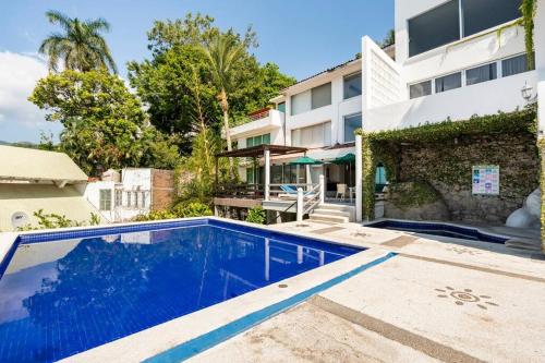a swimming pool in front of a building at Hermosa Villa Puesta al SOL in Acapulco