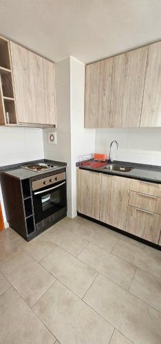 an empty kitchen with a stove and a sink at Departamento Centro de Valdivia, Caupolican in Valdivia