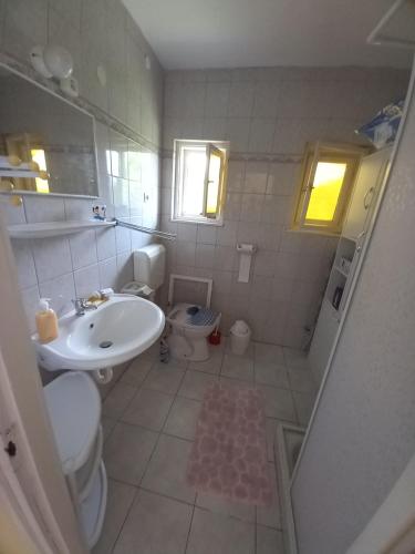 uma casa de banho branca com um lavatório e um WC em View Berry House em Csopak