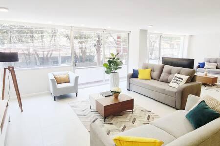 a living room with couches and chairs and a large window at Leonora MaiaHome-Amplio apt en Polanco a pasos de Masaryk 3BD + 3BT in Mexico City