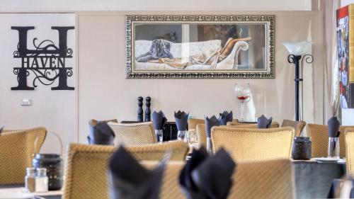 a dining room with chairs and a picture on the wall at Silver Haven Motor Inn in Broken Hill