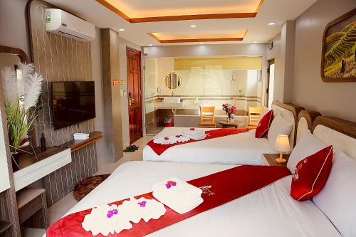 a hotel room with two beds and a television at En Hotel Sapa in Sa Pa