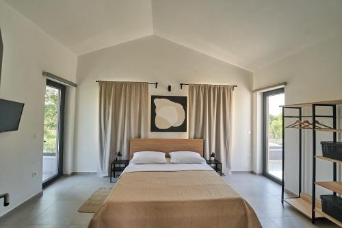 een slaapkamer met een groot bed in een kamer met ramen bij Villa Barbara in Poreč