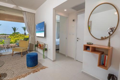 a living room with a mirror and a room with a view at Mina's Suites - קיסריה in Caesarea
