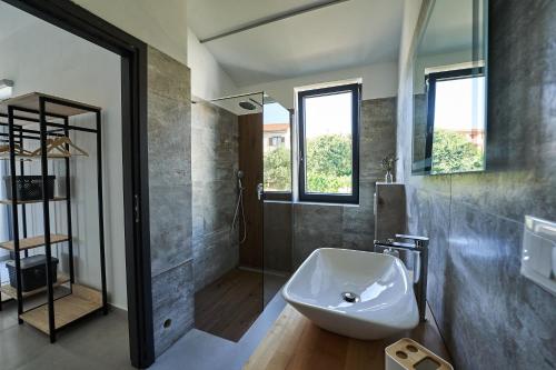 ein Badezimmer mit einem weißen Waschbecken und einer Dusche in der Unterkunft Villa Barbara in Poreč