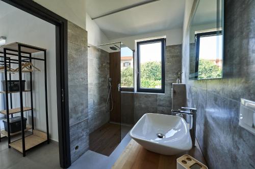 een badkamer met een witte wastafel en een douche bij Villa Barbara in Poreč