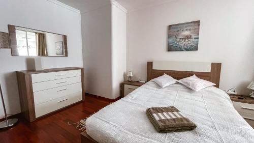 1 dormitorio con cama, tocador y espejo en Reis Magos Beach Caniço Sea line Apartment, en Caniço