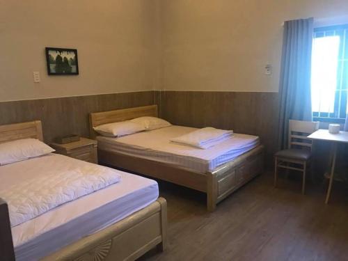 1 dormitorio con 2 camas y escritorio con escritorio en NHÀ KHÁCH HOA SEN, en Kinh Dinh