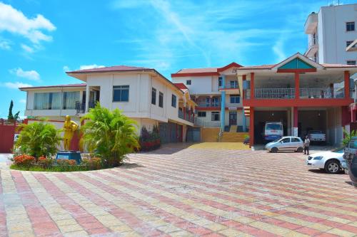 um parque de estacionamento em frente a alguns edifícios em Mawuli Hotel em Obuassi