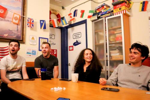 a group of people sitting around a table at ITH San Francisco Pacific Tradewinds Backpacker Hostel in San Francisco