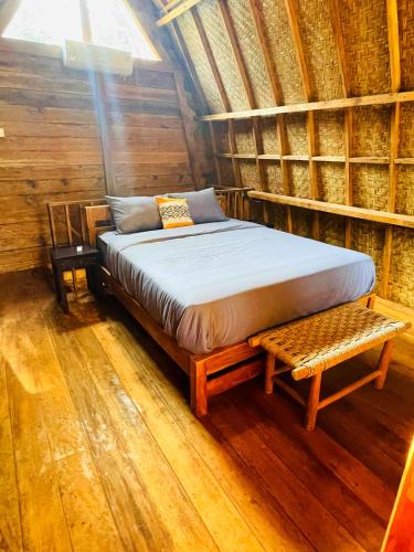 - un lit dans une chambre avec un banc à côté dans l'établissement SAJA Cottage, Gili Meno, à Gili Meno