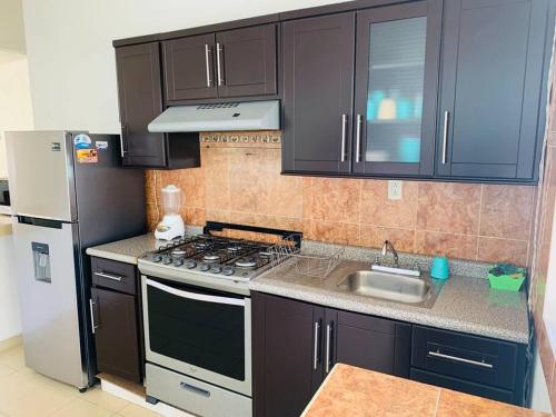 uma cozinha com um fogão, um lavatório e um frigorífico em Hermosa casa de descanso, alberca privada, caldera em Oaxtepec