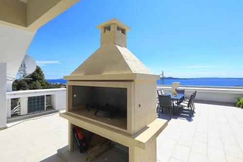 a stone fireplace on the patio of a house at Vidalis, no 1 in Kožino