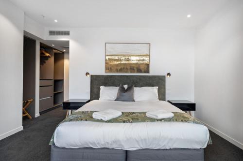 a bedroom with a large bed with two pillows at The Essence of Queenstown in Queenstown