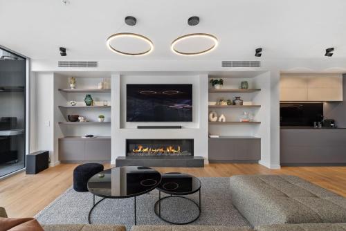 a living room with a fireplace and a tv at The Essence of Queenstown in Queenstown