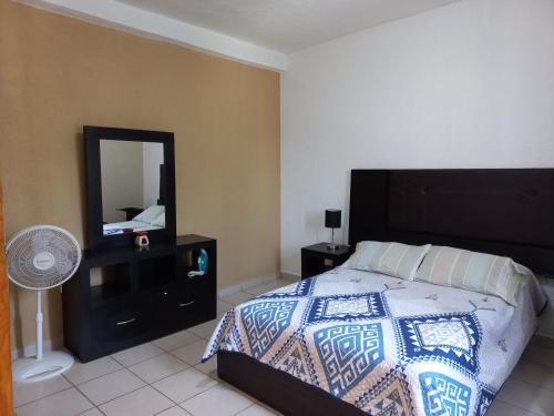 een slaapkamer met een bed en een dressoir met een spiegel bij Nice apartamento. 5 minutos del aeropuerto. in Mexico-Stad