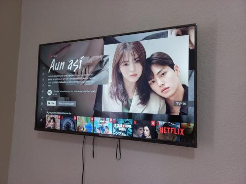 a flat screen tv hanging on a wall at Nice apartamento. 5 minutos del aeropuerto. in Mexico City