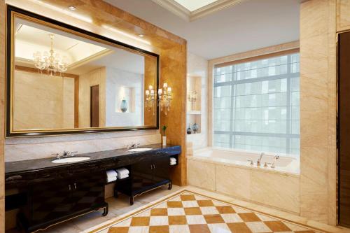 a bathroom with a large mirror and a tub and sink at The Westin Wuhan Wuchang in Wuhan