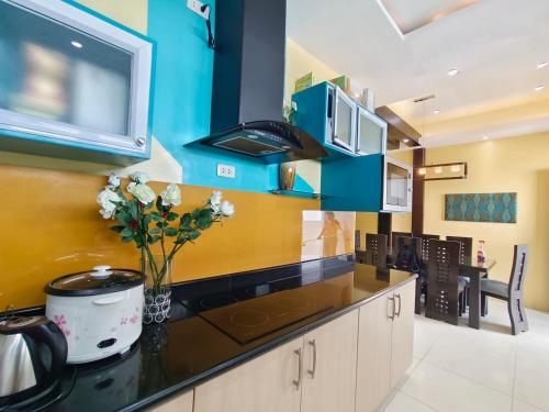 a kitchen with a counter with a vase of flowers at Mackenzie Penthouse Taal View with balcony in Tagaytay