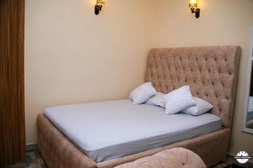 a bed with two pillows on it in a room at Denverwing Homes in Eldoret