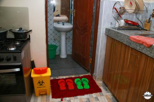 a kitchen with a pair of slippers and a sink at Denverwing Homes in Eldoret